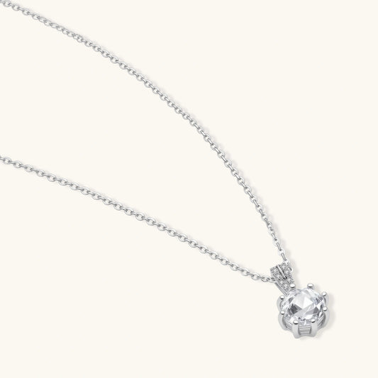 Platinum-plated sterling silver necklace with round clear crystal pendant and decorative bail on neutral background.