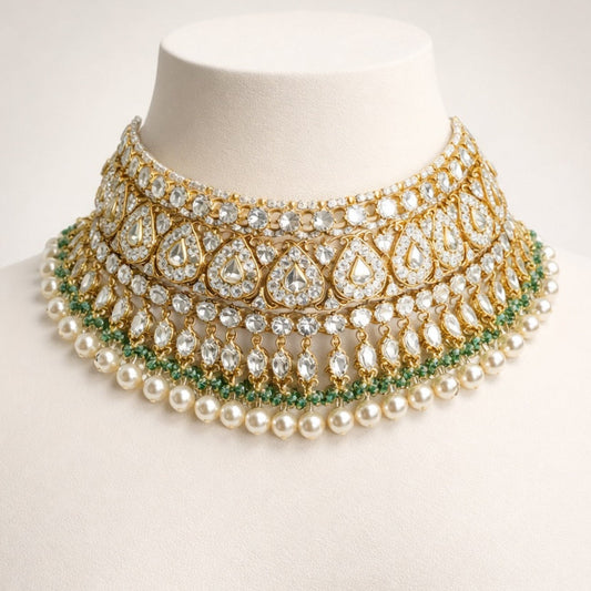 Ornate necklace with pearls and gemstones on a mannequin head against a white background