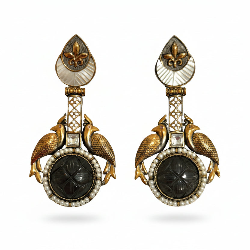 A pair of gold-plated, Egyptian style ethnic dangler earrings with faux carved ruby stones and mother-of-pearl embellishments, featuring intricate filigree framing.