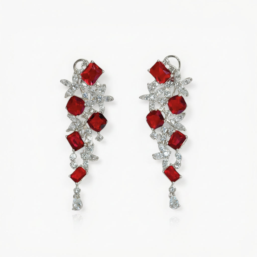 Pair of earrings with red gemstones on a white background