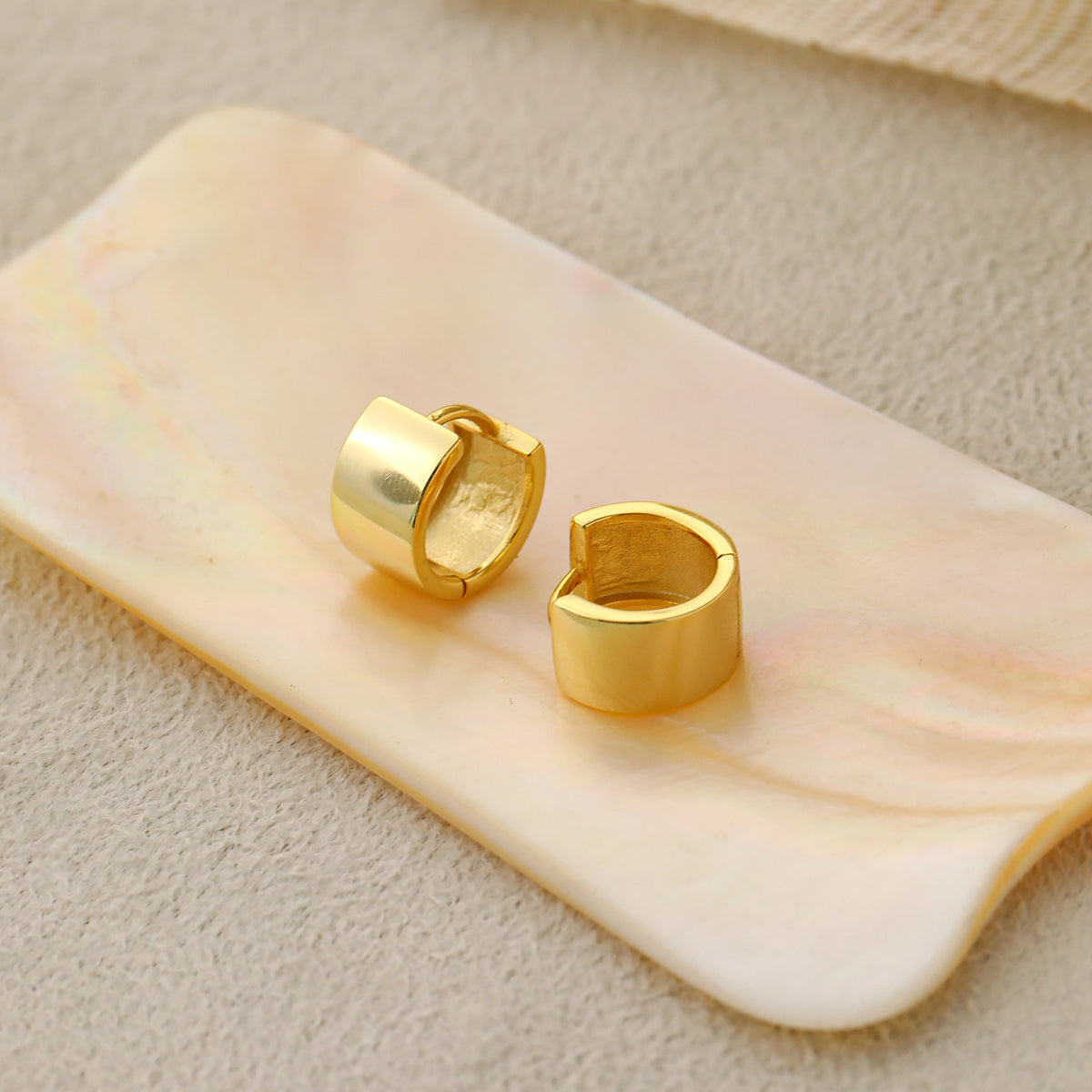 Mini Circle Huggie Earrings in 925 sterling silver. Compact circular huggies with broad polished surfaces.