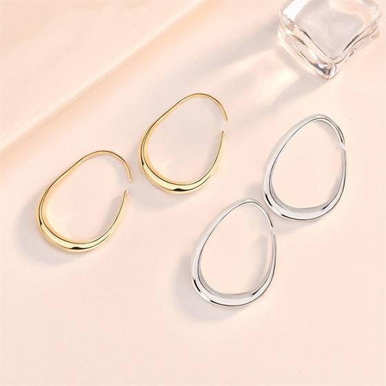 Open Teardrop Hoop Earrings in 925 sterling silver. Elongated open teardrops create a fluid outline at the ear.