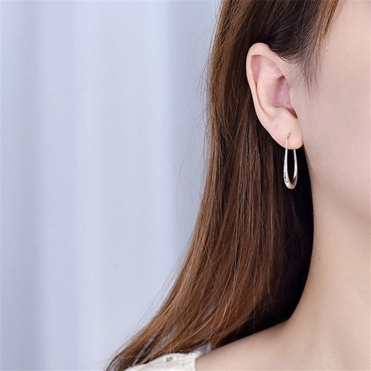 Open Teardrop Hoop Earrings in 925 sterling silver. Elongated open teardrops create a fluid outline at the ear.