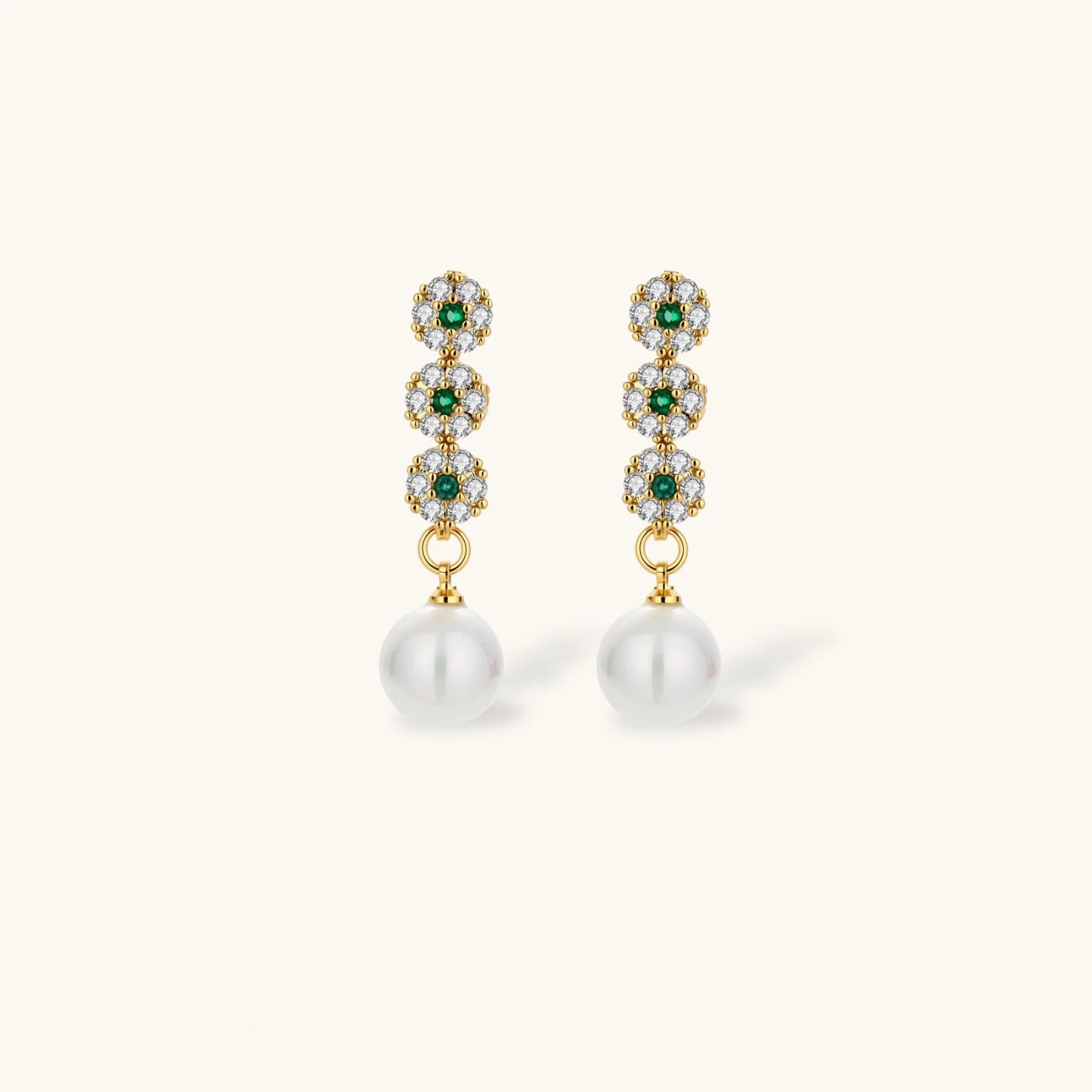 Gold-plated jewelry set with green cubic zirconia floral motifs, featuring matching necklace and pearl drop earrings