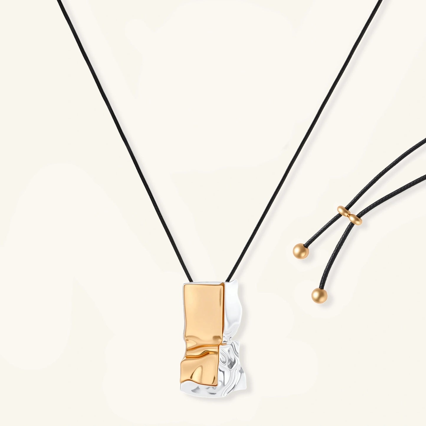 Abstract sculptural pendant necklace with gold and silver toned eco-zinc alloy on black adjustable cord with brass bead details