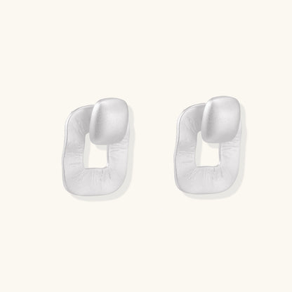 Pair of geometric sterling silver earrings with frosted square frames and glossy rounded studs on white background