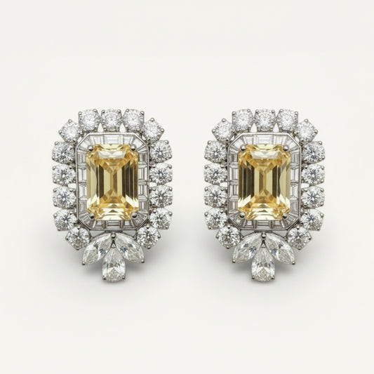 Pair of diamond earrings with yellow gemstones on a white background