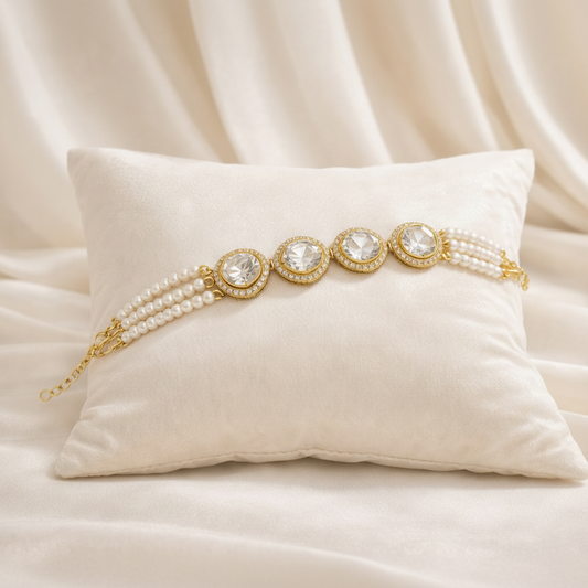 Gold bracelet with pearls on a white pillow against a beige fabric background