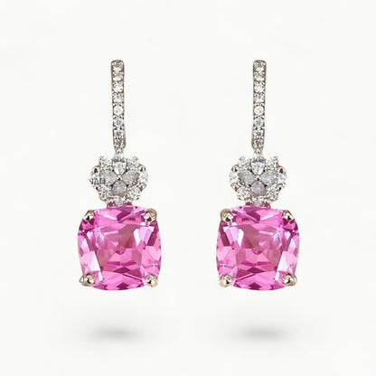 Pink gemstone earrings with diamond accents on a white background