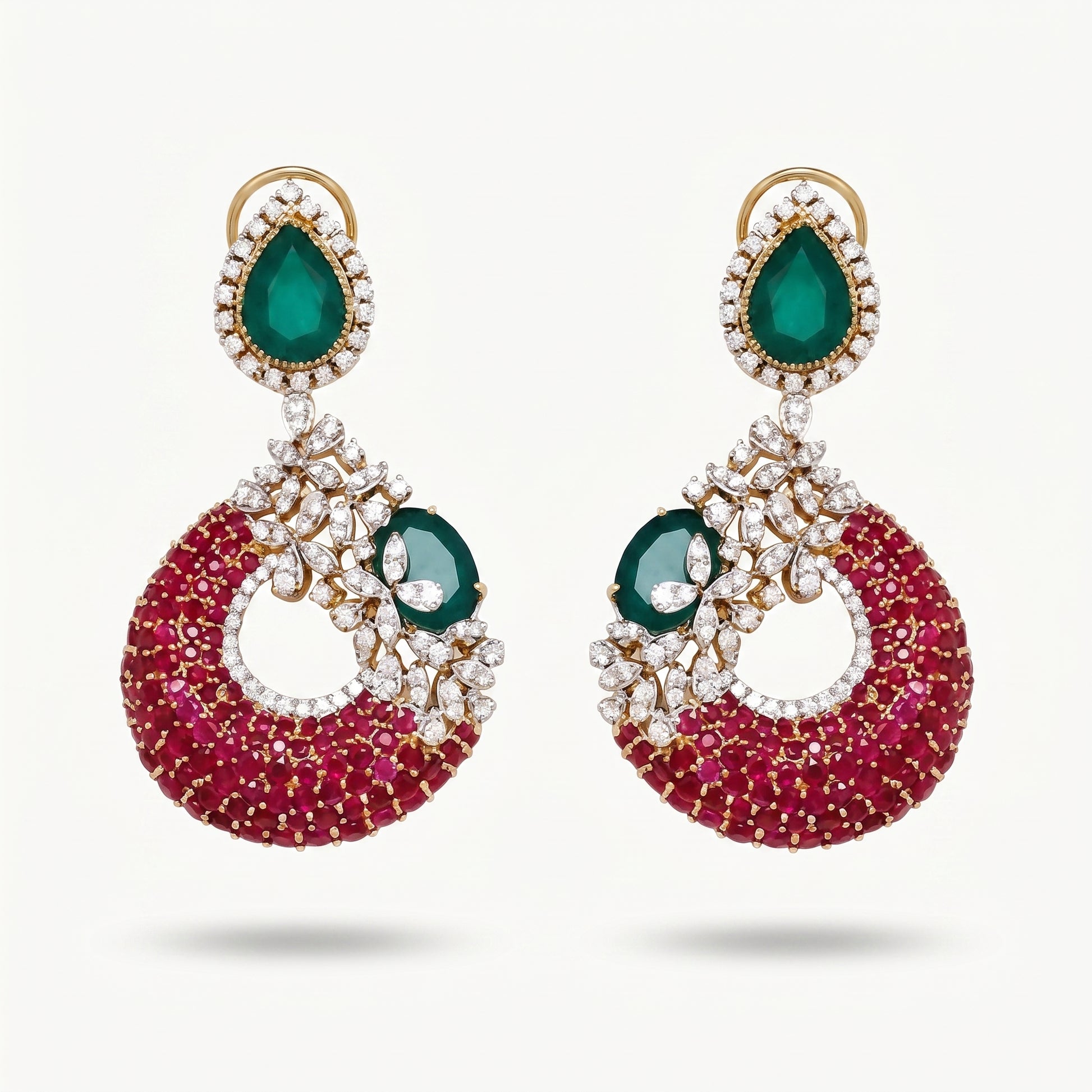 A pair of gold-plated drop earrings featuring a large teardrop-shaped green emerald stone at the top, surrounded by small clear stones, and a crescent-shaped lower section covered in deep pinkish-red stones with a smaller green emerald and clear stone detail.