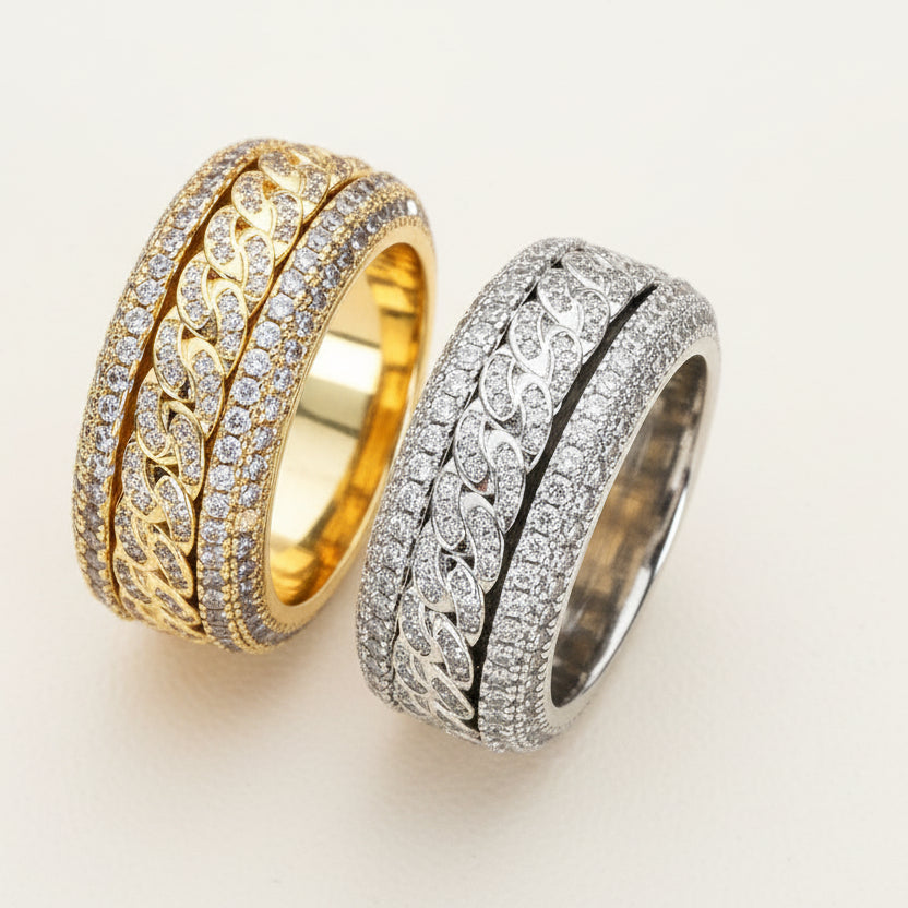 Two 18K gold inlaid zircon rings with rotatable designs, one with a gold base and the other with a silver base, set on a dark background.
