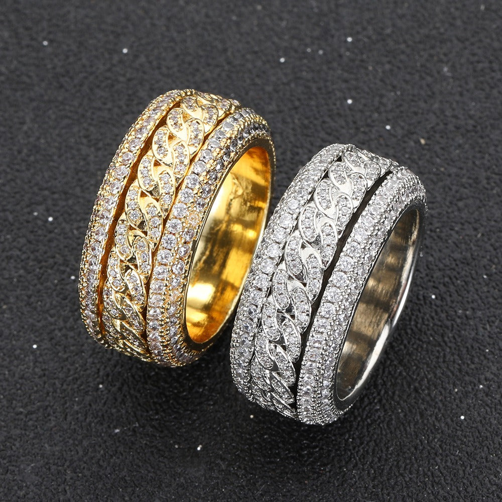 Two 18K gold inlaid zircon rings with rotatable designs, one with a gold base and the other with a silver base, set on a dark background.