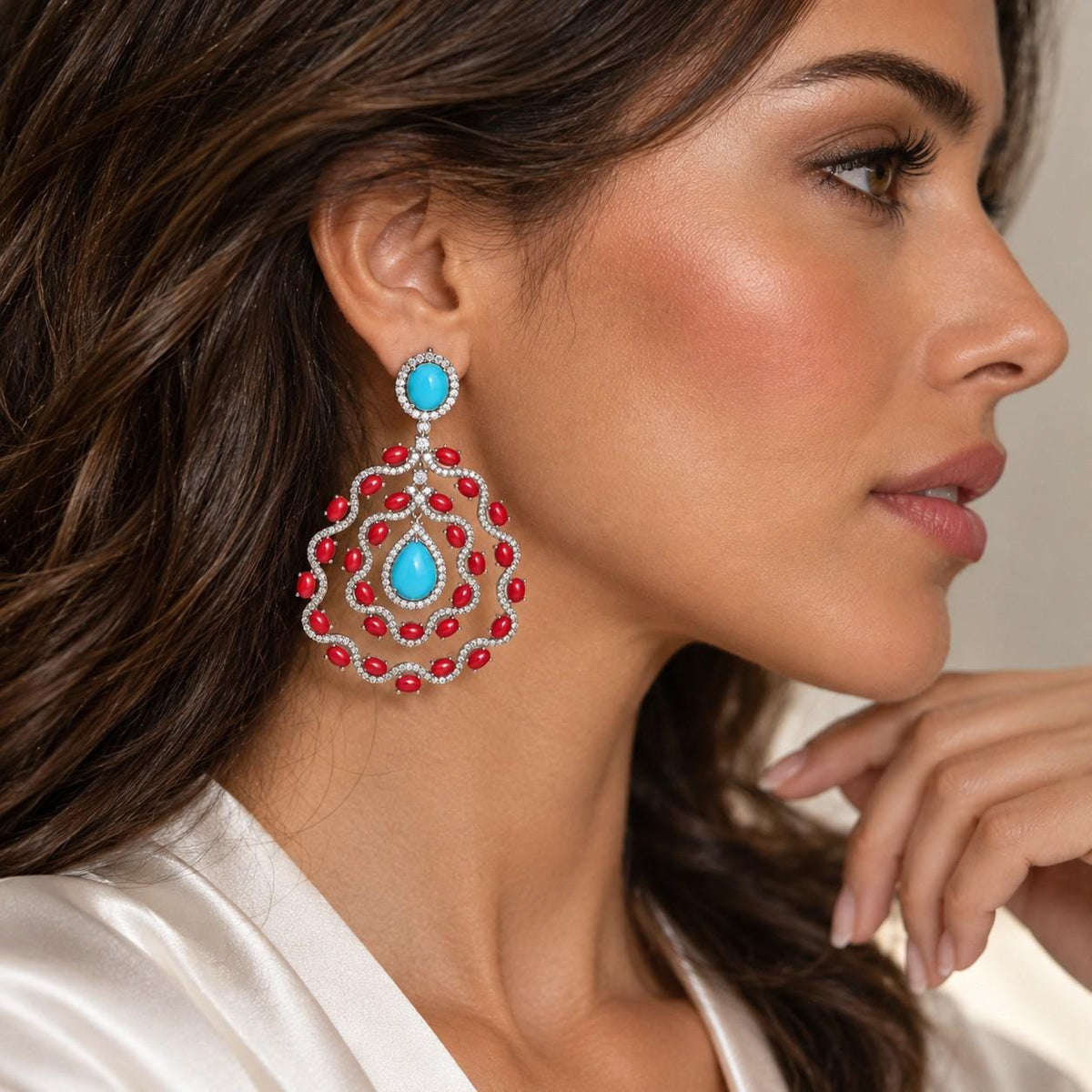Turquoise and coral chandelier earrings worn by a model