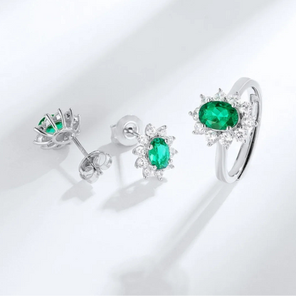 Emerald oval halo earrings beside a coordinating ring; earrings only