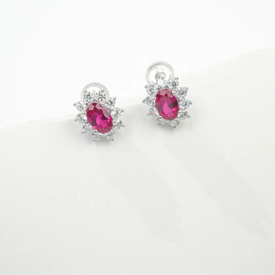 Ruby oval halo stud earrings in sterling silver
