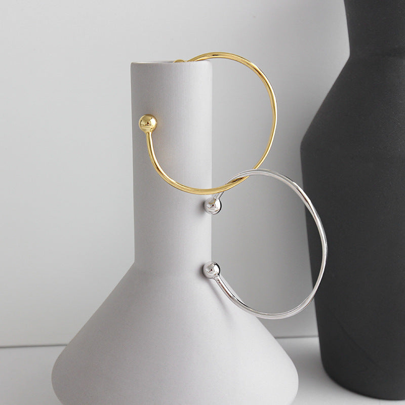 Bead End Open Bangle in 925 sterling silver. A slim adjustable band meets two polished bead ends.
