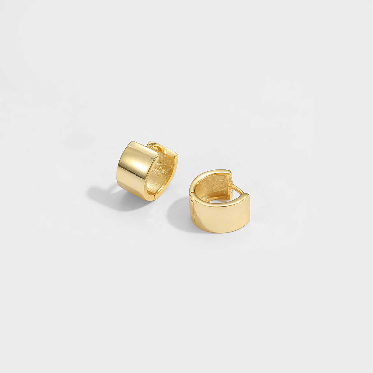 Mini Circle Huggie Earrings in 925 sterling silver. Compact circular huggies with broad polished surfaces.
