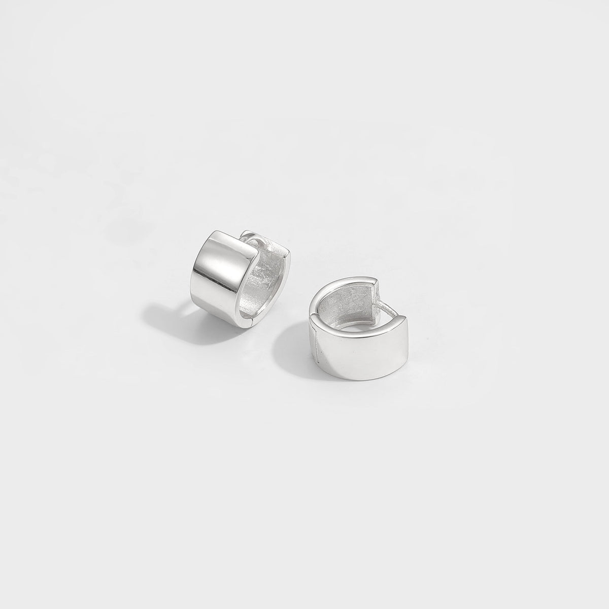 Mini Circle Huggie Earrings in 925 sterling silver. Compact circular huggies with broad polished surfaces.