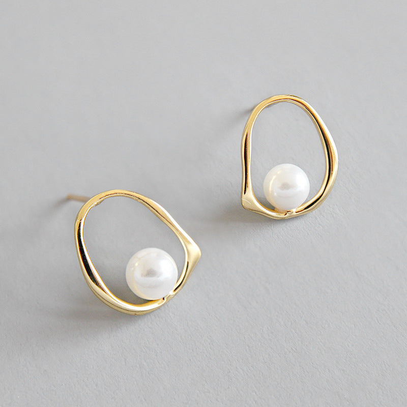 Open Oval Shell Pearl Stud Earrings in 925 sterling silver. A white shell pearl sits within a softly irregular open oval.