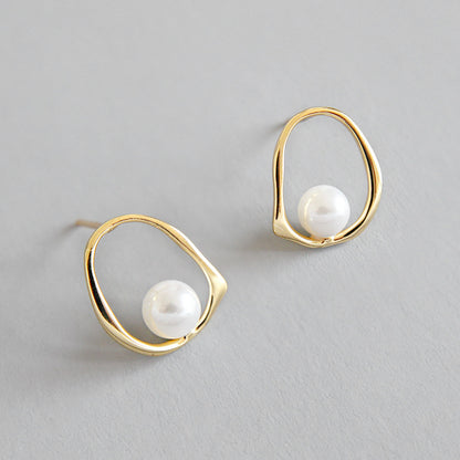 Open Oval Shell Pearl Stud Earrings in 925 sterling silver. A white shell pearl sits within a softly irregular open oval.