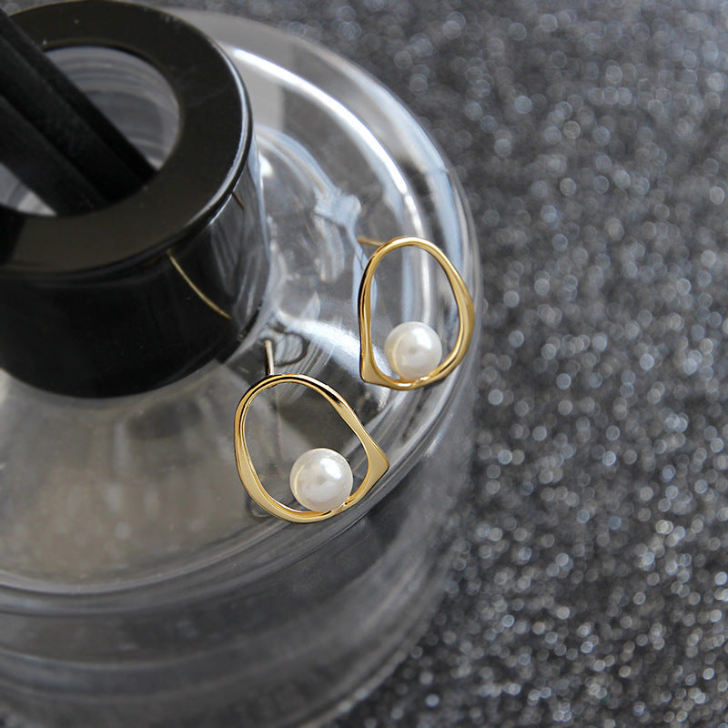 Open Oval Shell Pearl Stud Earrings in 925 sterling silver. A white shell pearl sits within a softly irregular open oval.