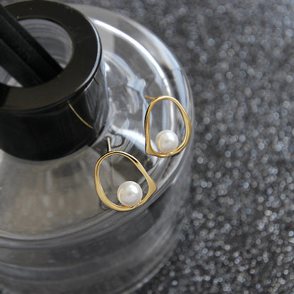 Open Oval Shell Pearl Stud Earrings in 925 sterling silver. A white shell pearl sits within a softly irregular open oval.