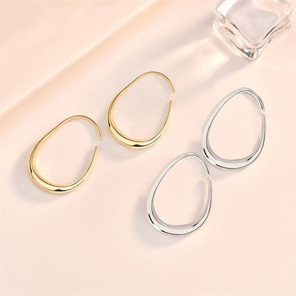 Open Teardrop Hoop Earrings in 925 sterling silver. Elongated open teardrops create a fluid outline at the ear.