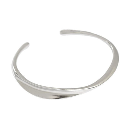 Twisted Curve Open Bangle in 925 sterling silver. A broad polished band turns into a fluid, sculptural twist.