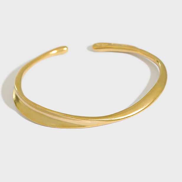 Twisted Curve Open Bangle in 925 sterling silver. A broad polished band turns into a fluid, sculptural twist.