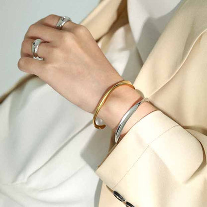 Twisted Curve Open Bangle in 925 sterling silver. A broad polished band turns into a fluid, sculptural twist.