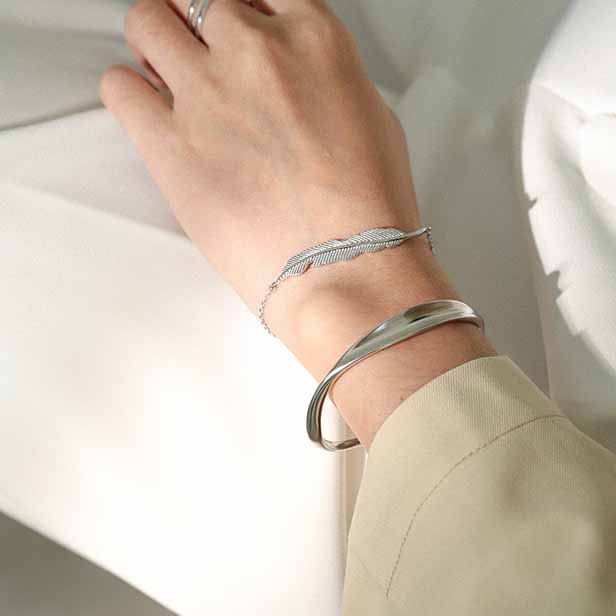 Twisted Curve Open Bangle in 925 sterling silver. A broad polished band turns into a fluid, sculptural twist.